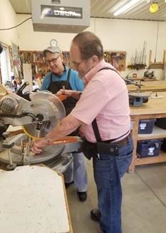Hobby Shop volunteer assists participant with a woodworking project