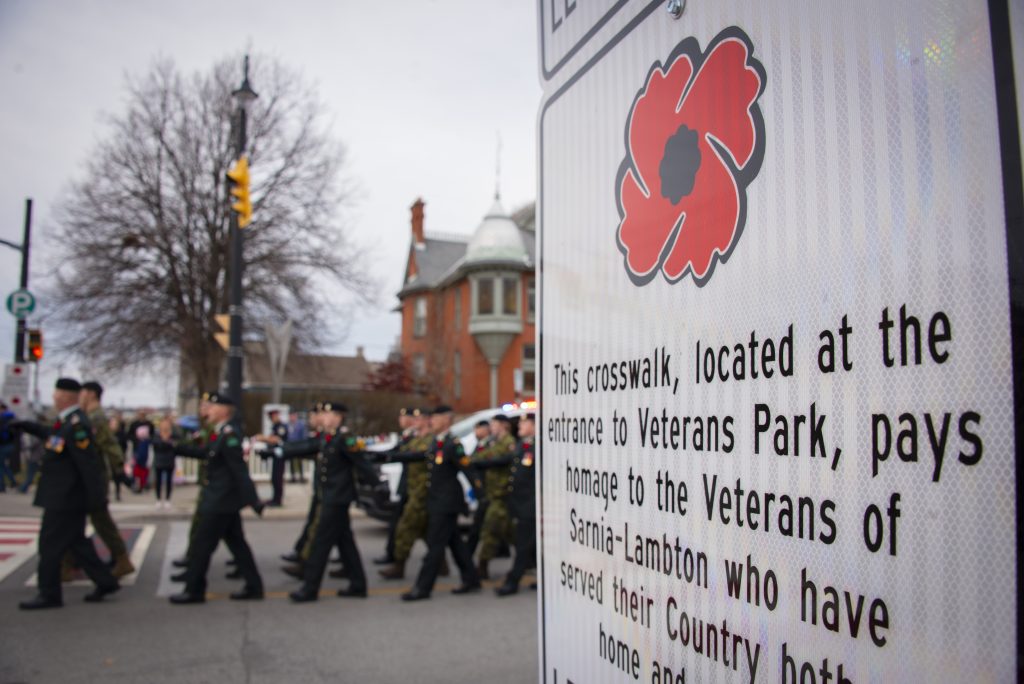 Soldier passing a remembrance day sign.