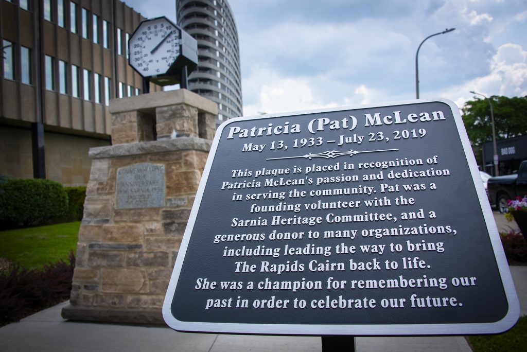 Plaque with historical information in front of a stone monument.