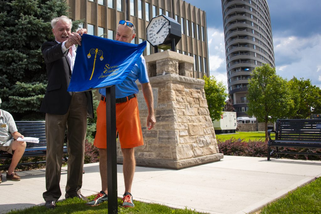 Mayor Mike Bradley and Ted McLean unveil a plaque honouring the late Patricia McLean on the grounds of City Hall.