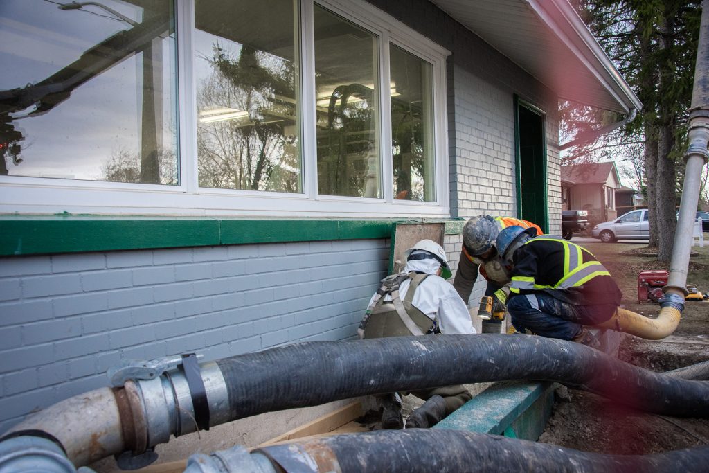 Three workers doing repairs on a pumping station.
